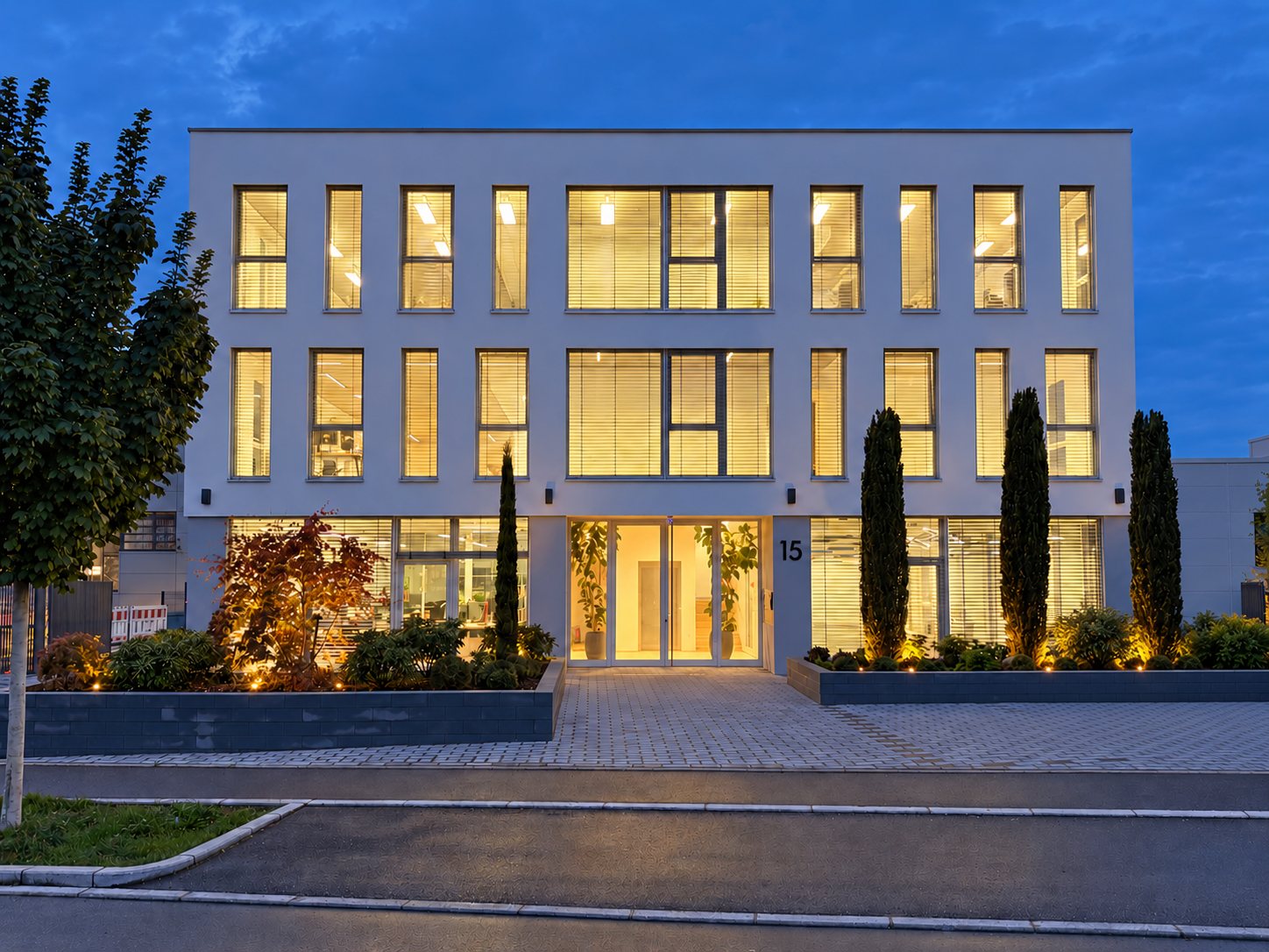 Das Gebäude Bertha-Benz-Straße 15 in Aichtal am Abend, die Fenster sind hell erleuchtet